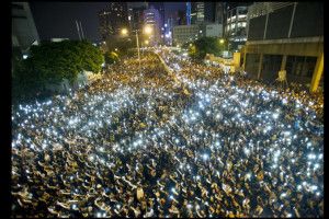 Manifestanti e cellulari accesi, durante la protesta davanti alla sede del Consiglio Legislativo di Hong Kong.